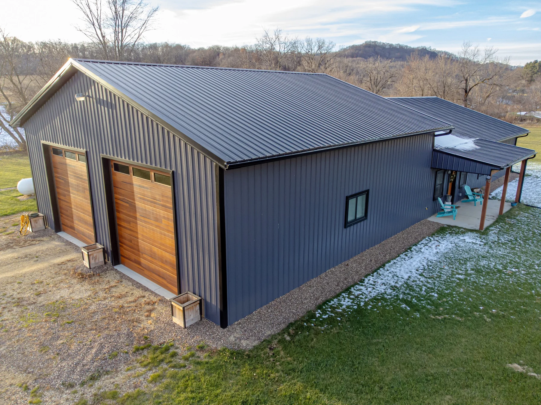 Illustrative photo of a metal-sided barndominium with garage bays and a covered entry