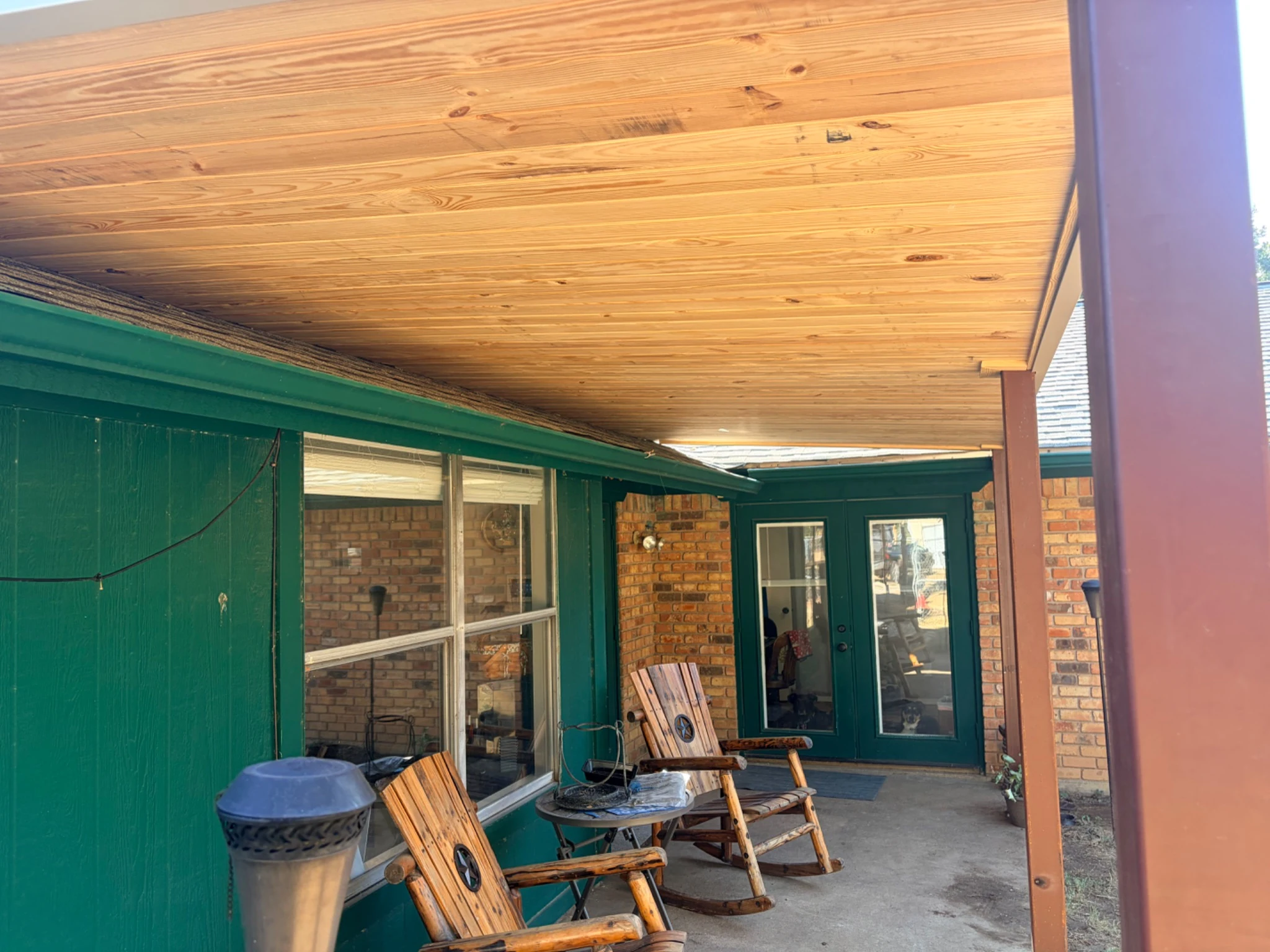 Company-supplied close view looking along the wood-paneled underside of a solid patio roof